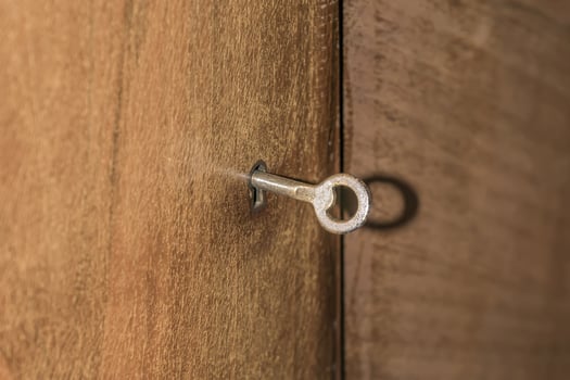 antique key in lock of wooden cabinet photo