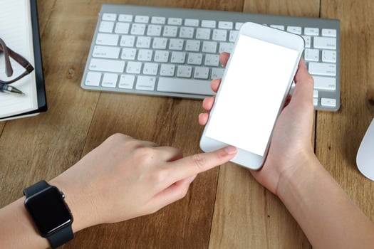 woman hand holding empty screen of smart-phone on wood desk work. photo