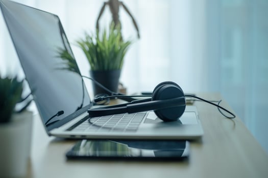 Headset headphones telephone and laptop in home office call center photo