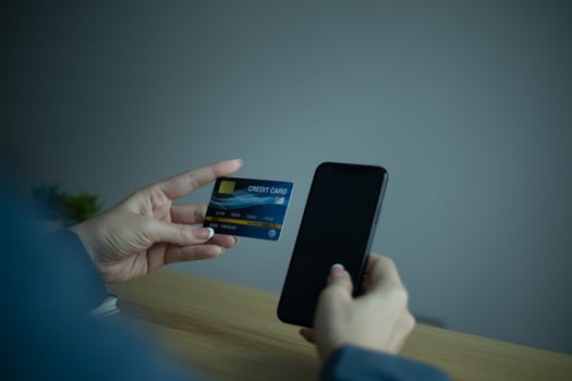 Hand holding credit card and using computer. Shopping online, e-commerce, internet banking, working from home concept. photo