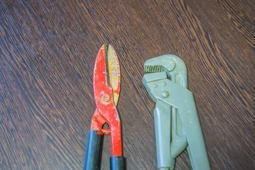 scissors for cutting metal and gas wrench on wooden table photo