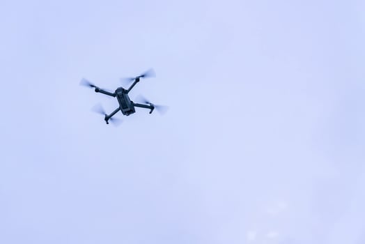 flying drone against blue sky photo