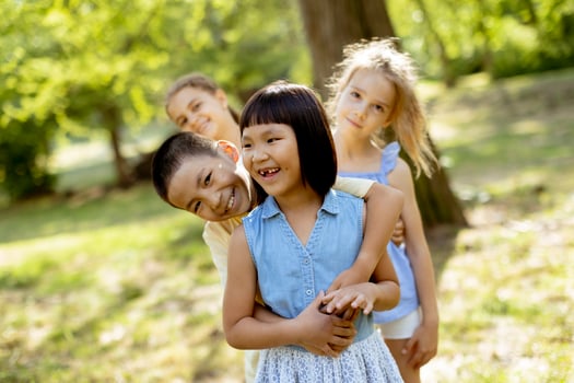 Group of asian and caucasian kids having fun in the park photo