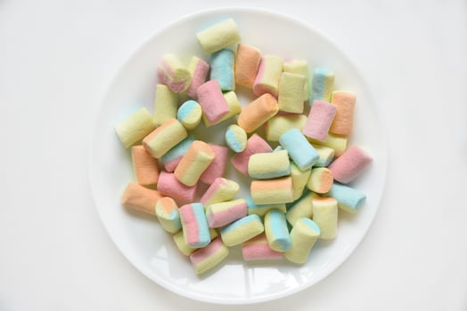Colorful sweet marshmallows on a white plate. Delicious marshmallows for coffee. photo