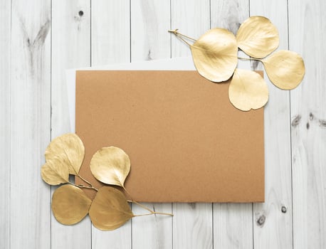 Mockup for a letter or a wedding invitation with gold leaves eucalyptus branches. photo