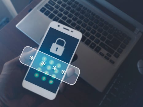 Cybersecurity essentials on smartphones. Digital cyber crime by anonymous hackers. Men hand holding a phone on a laptop with 3d icons password for personal data security and finance. photo