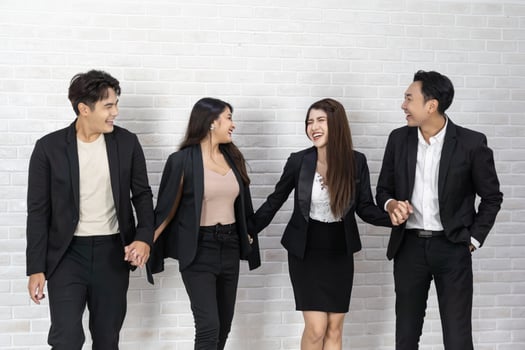 The business people standing on the white wall background. Group Of Happy Business People Standing In Pose Over White Background photo