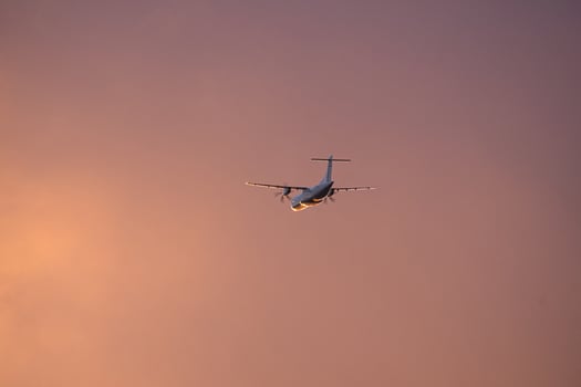 Plane in the evening sky in luminous horizon. It goes on vacation photo