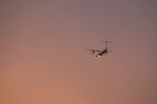 airplane in the evening sky in luminous horizon. photo