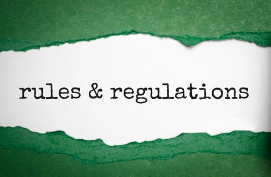 rules and regulations word under torn green paper photo