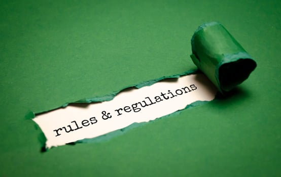 rules and regulations word under torn green paper photo