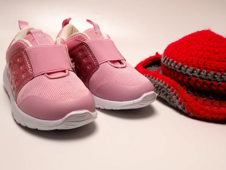 Picture of red color with grey stripes crochet hat and a pair of pink shoes photo