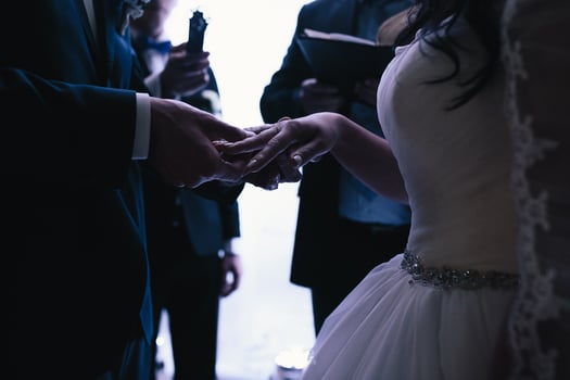 groom wears the ring bride photo