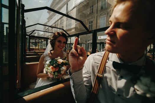 Bride and groom posing in a tour car photo