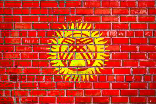 National  flag of the Kyrgyzstan  on a grunge brick background. photo