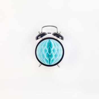 Black alarm clock with blue paper ball concept photo