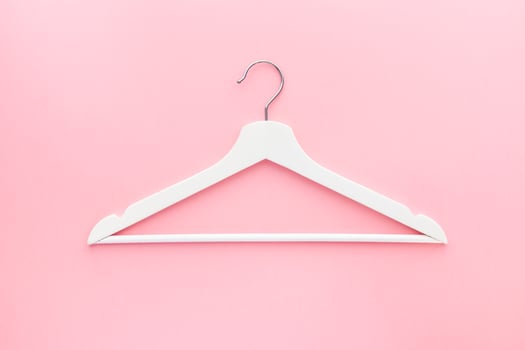White hangers on pastel pink background photo