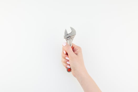 Female hand holding spanner on white background photo