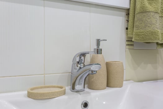 Soap and shampoo dispensers near Ceramic Water tap sink with faucet in expensive loft bathroom or kitchen photo