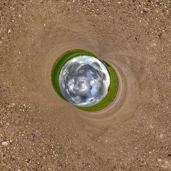 Inversion of blue little planet transformation of spherical panorama 360 degrees. Spherical abstract aerial view on road with awesome beautiful clouds. Curvature of space. photo