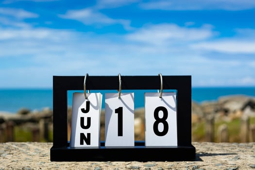 Jun 18 calendar date text on wooden frame with blurred background of ocean. photo