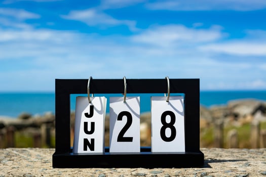 Jun 28 calendar date text on wooden frame with blurred background of ocean. photo