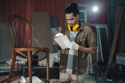 Young Asian man Carpenter working in woodcraft carpentry workshop. photo