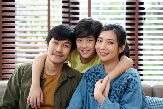 portrait of happy Asian family spending time together on sofa in living room. family and home concept. photo