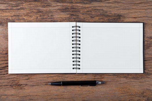 Blank note pad with pen on wood background photo