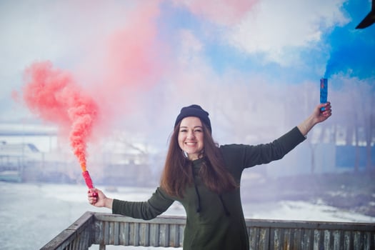 Young girl with blue and red colored smoke bomb in hands. photo
