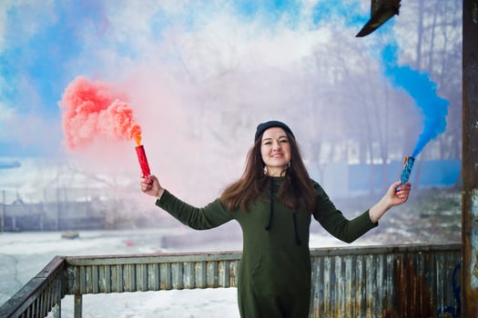 Young girl with blue and red colored smoke bomb in hands. photo