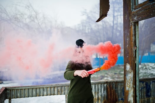 Young girl with blue and red colored smoke bomb in hands. photo