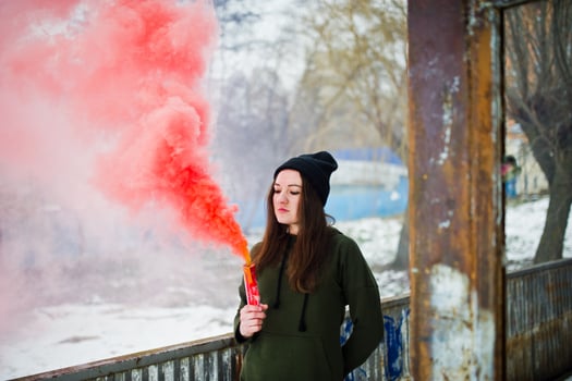 Young girl with red colored smoke bomb in hand. photo