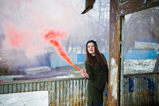 Young girl with red colored smoke bomb in hand. photo