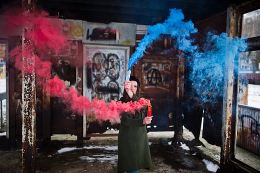Young girl with blue and red colored smoke bomb in hands. photo