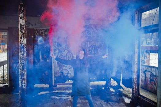 Young girl with blue and red colored smoke bomb in hands. photo