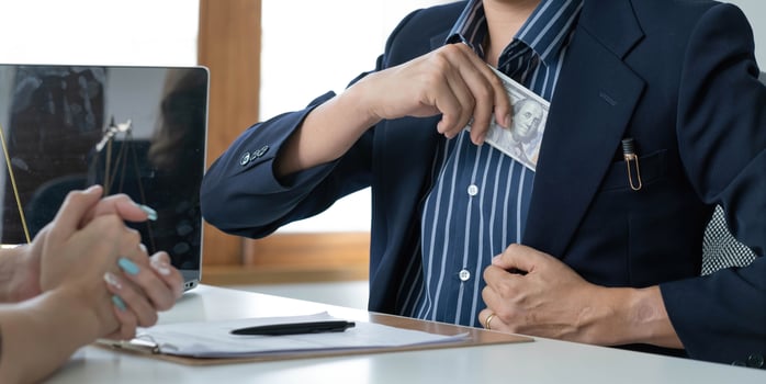 A businessman take a dollar money banknote into his suit pocket. Corruption and bribery concept. cropped image photo
