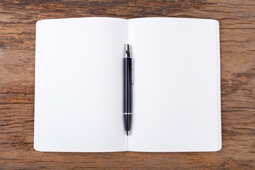 Blank note pad with pen on wood background photo