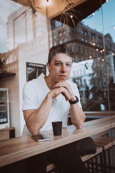 Young, handsome man is drinking his morning coffee in a cafe. photo