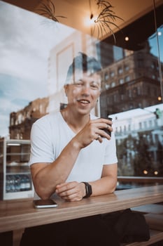Young, handsome man is drinking his morning coffee in a cafe. photo