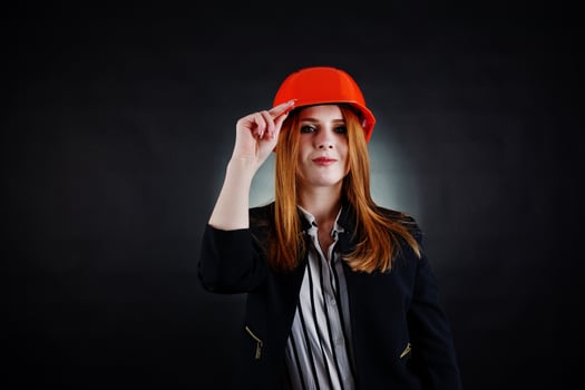 Engineer woman in orange protect helmet on studio black background. photo
