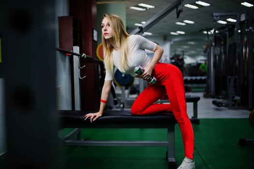 Young sport girl workout in gym. Fitness woman doing exercises with dumbbells. photo