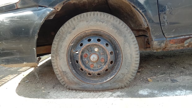 old sedan car is not maintained with a flat tire wheel photo