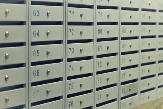Many posting metal mailboxes with room number at residential building photo