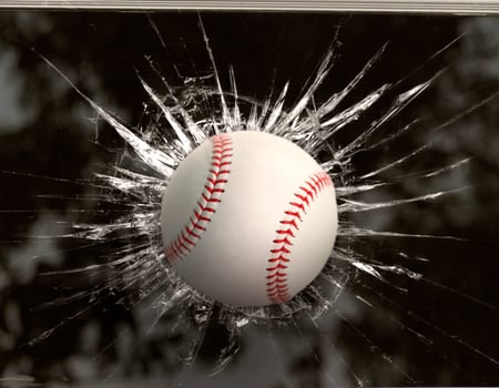 Baseball through broken window photo