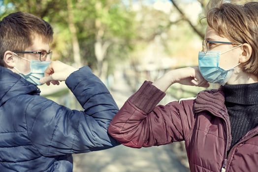 Two people bump elbows to avoid coronavirus outdoors. Friends demonstrating a new way of greeting during coronavirus epidemic. Health care concept. Social distancing. photo