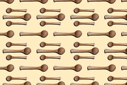 Wooden spoons, top view of wooden spoons isolated on yellow background. Kitchenware pattern background. photo