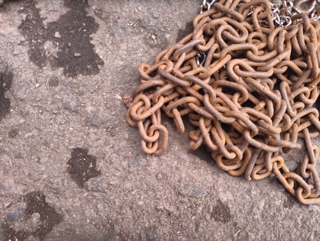 rusty iron chain lying on the asphalt road photo