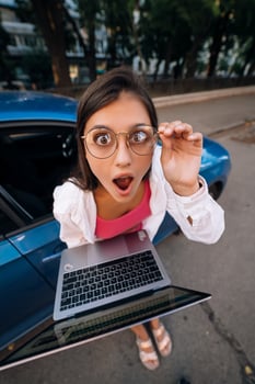 Shocked young brunette hold in hands laptop on the street photo