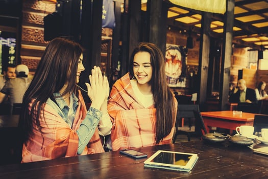 Two young and beautiful girls having fun in cafe photo